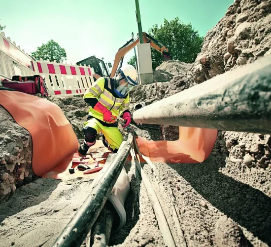 Utility worker fixing underground pipes